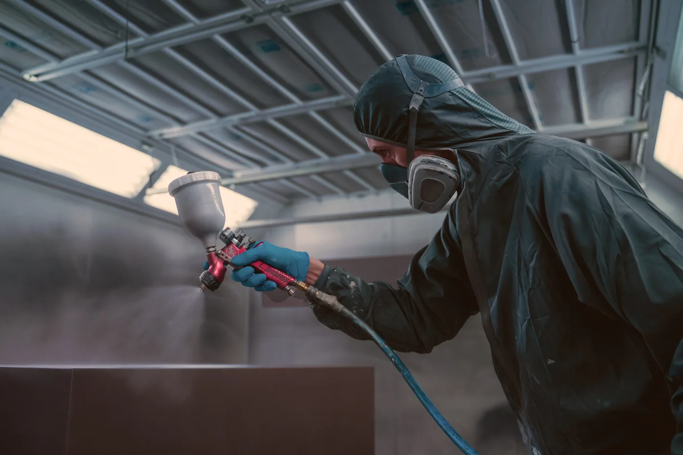 Spuiter werkt een meubelfront af in de spuiterij van de fabriek in Purmerend